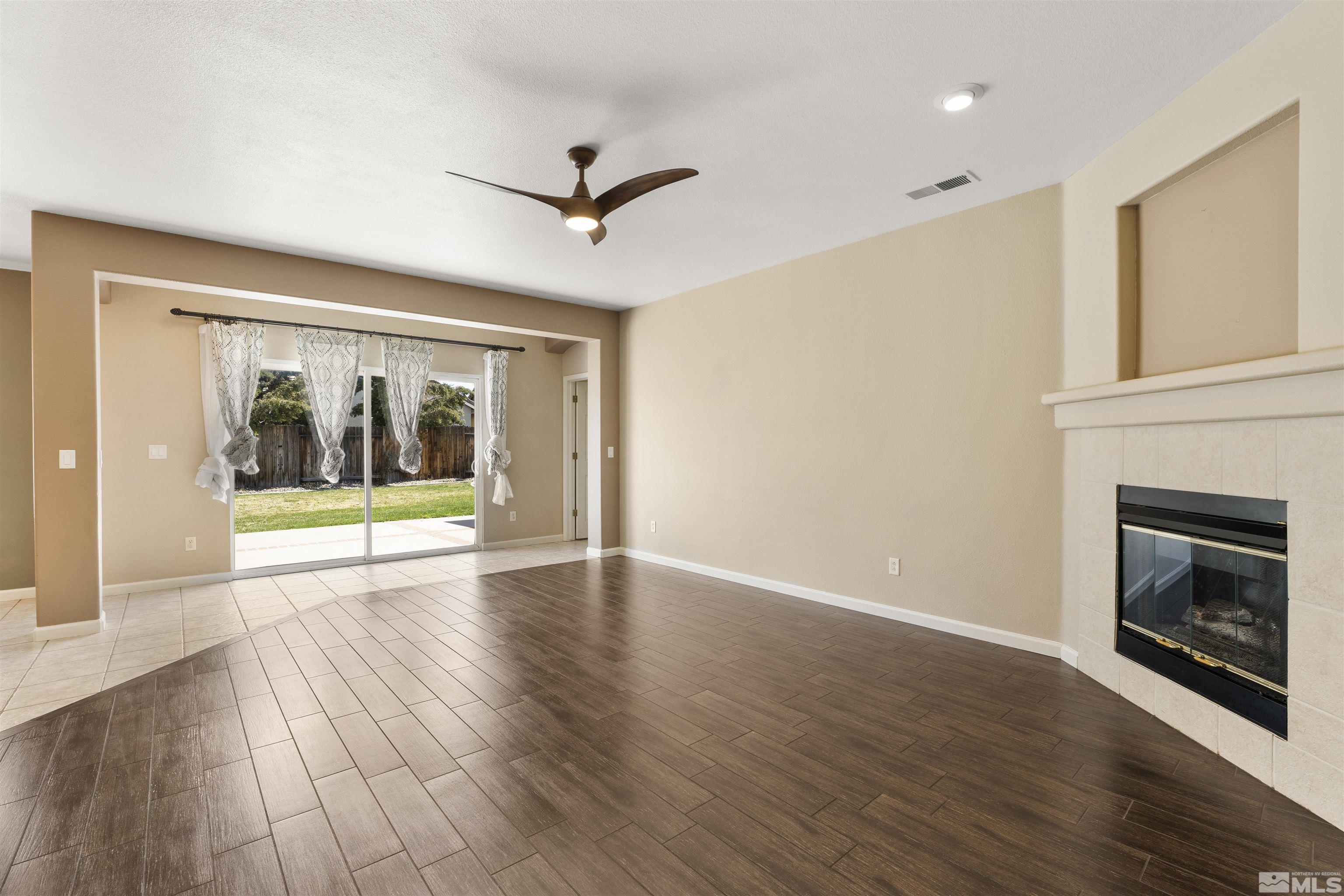 10200 Wolf Ridge Way Reno, NV 89521 - Photo 4 of 40 a view of an empty room with a fireplace and a window