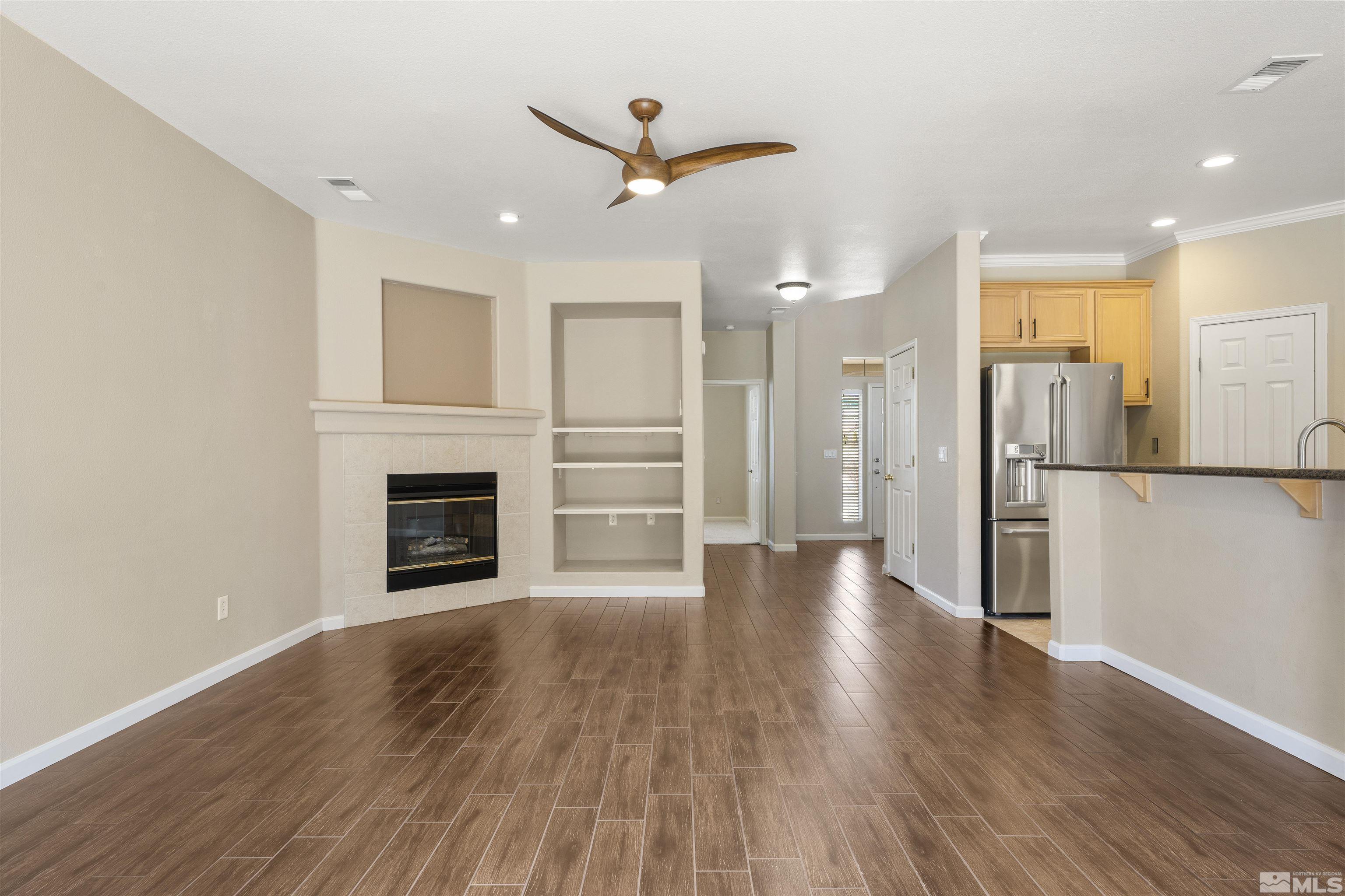 10200 Wolf Ridge Way Reno, NV 89521 - Photo 5 of 40 a view of a livingroom with wooden floor a ceiling fan and kitchen space