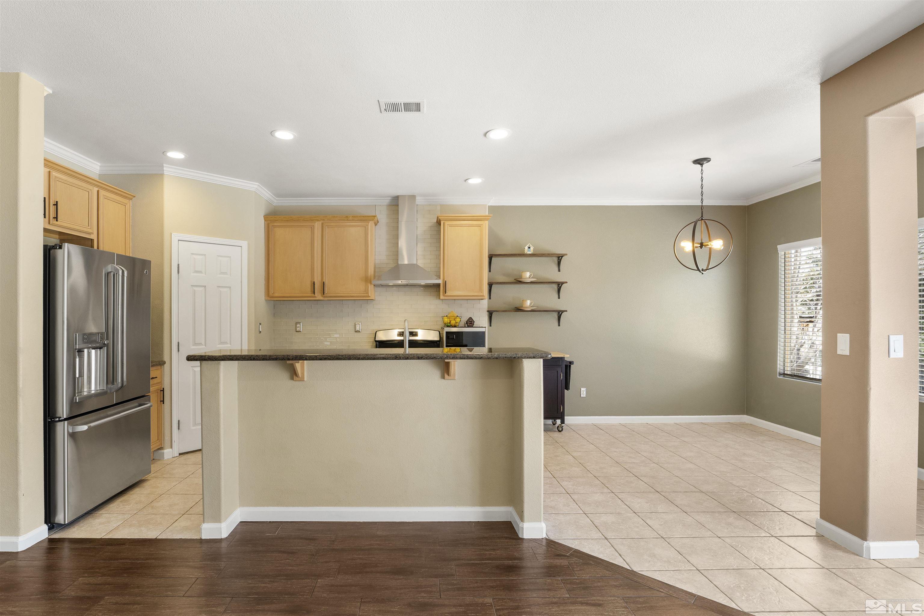 10200 Wolf Ridge Way Reno, NV 89521 - Photo 8 of 40 a kitchen with stainless steel appliances a refrigerator and a stove top oven