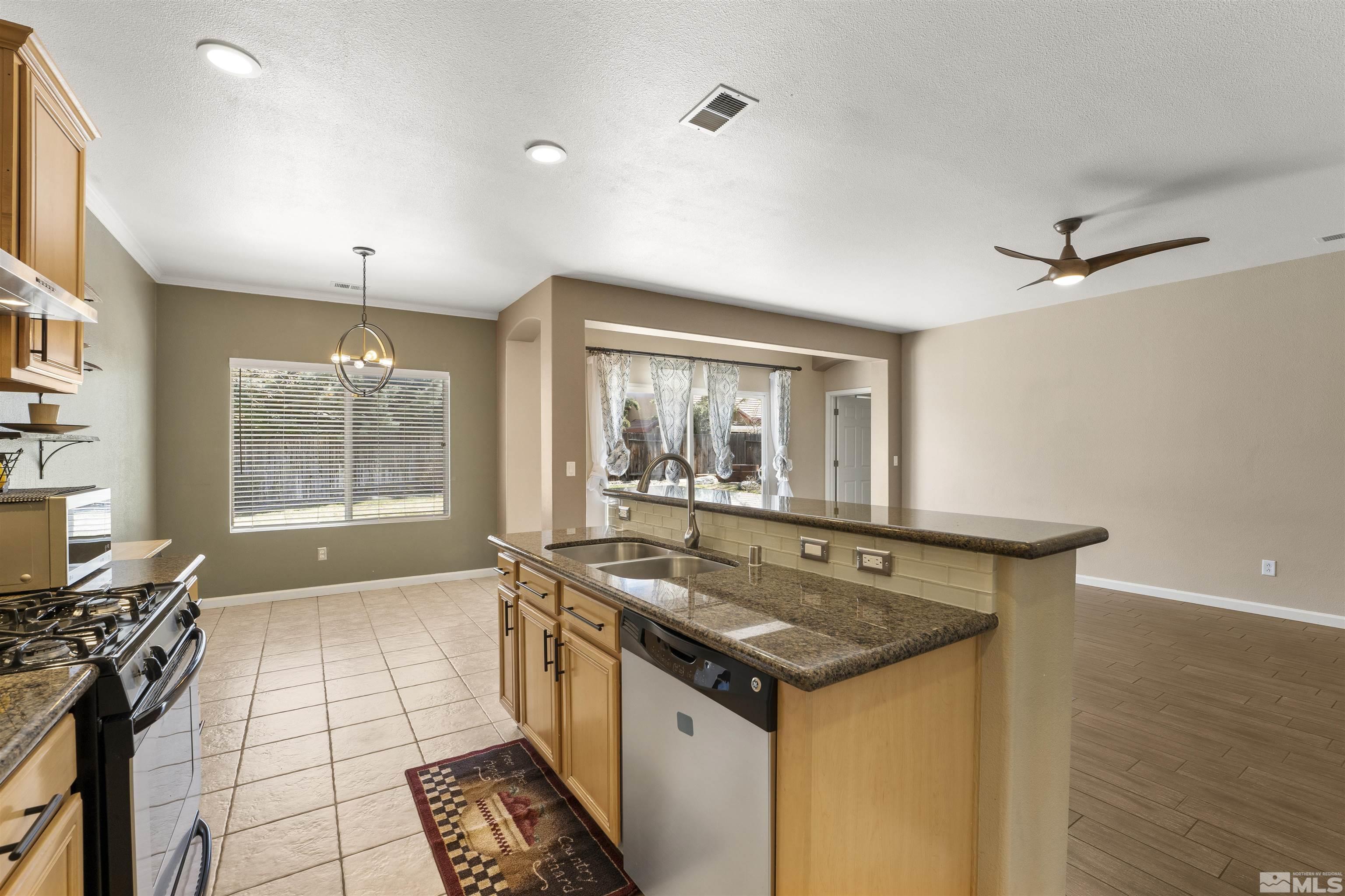 10200 Wolf Ridge Way Reno, NV 89521 - Photo 10 of 40 a kitchen with a sink and wooden cabinets