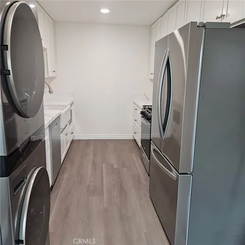a kitchen with stainless steel appliances white cabinets and a stove top oven
