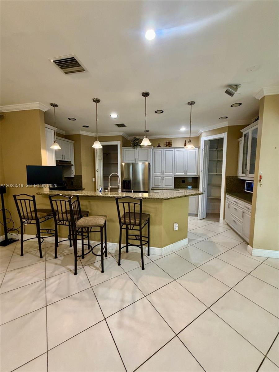 9444 Southwest 78th Street Miami, FL 33173 - Photo 6 of 11 a kitchen with stainless steel appliances kitchen island granite countertop a table and chairs in it