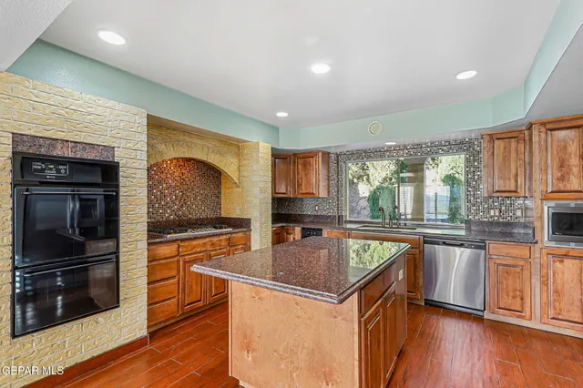 a kitchen with stainless steel appliances granite countertop a sink stove and refrigerator
