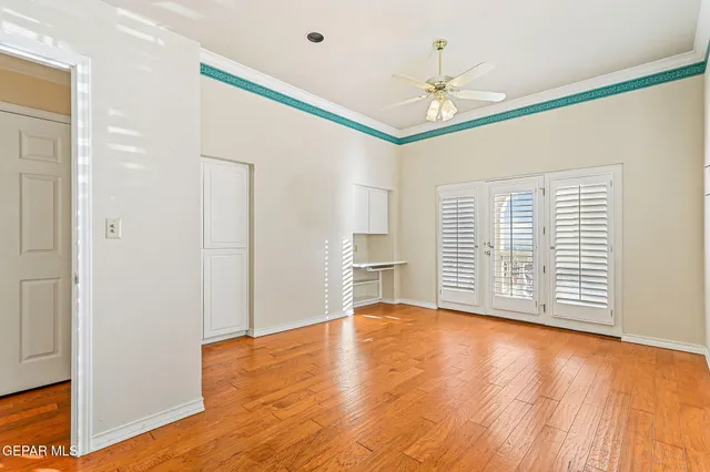 a view of an empty room with window and wooden floor