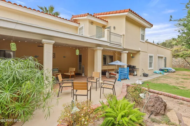a living room with furniture a ceiling fan and a large window