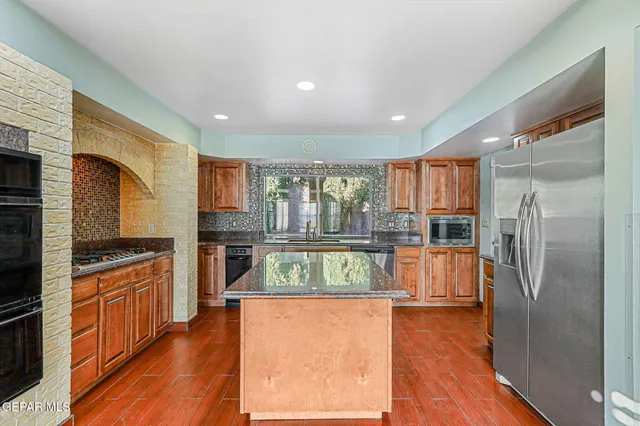 a view of an empty room with wooden floor and a fireplace