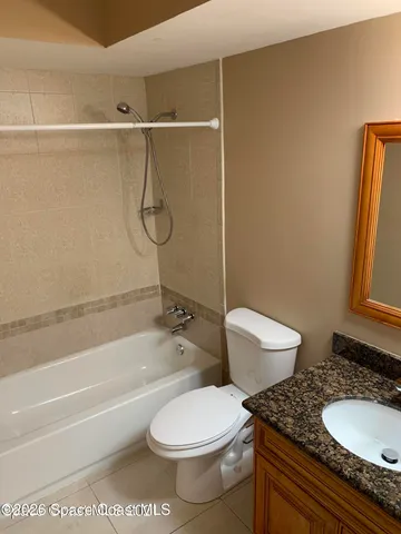 a bathroom with a granite countertop toilet sink and shower