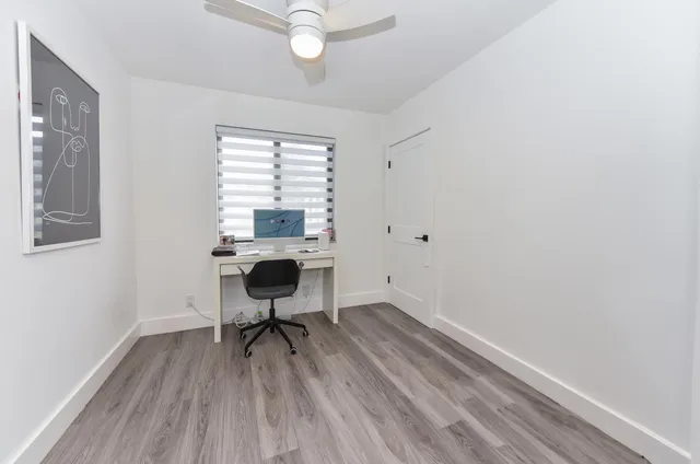 a view of a workspace with wooden floor