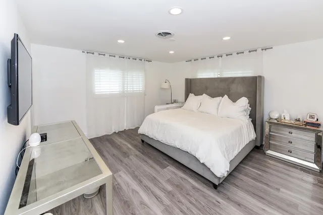 a bedroom with a bed and a flat screen tv