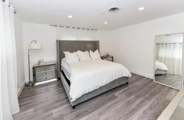 a bedroom with a bed and a mirror