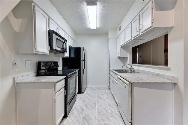 a kitchen with stainless steel appliances granite countertop a sink and a stove