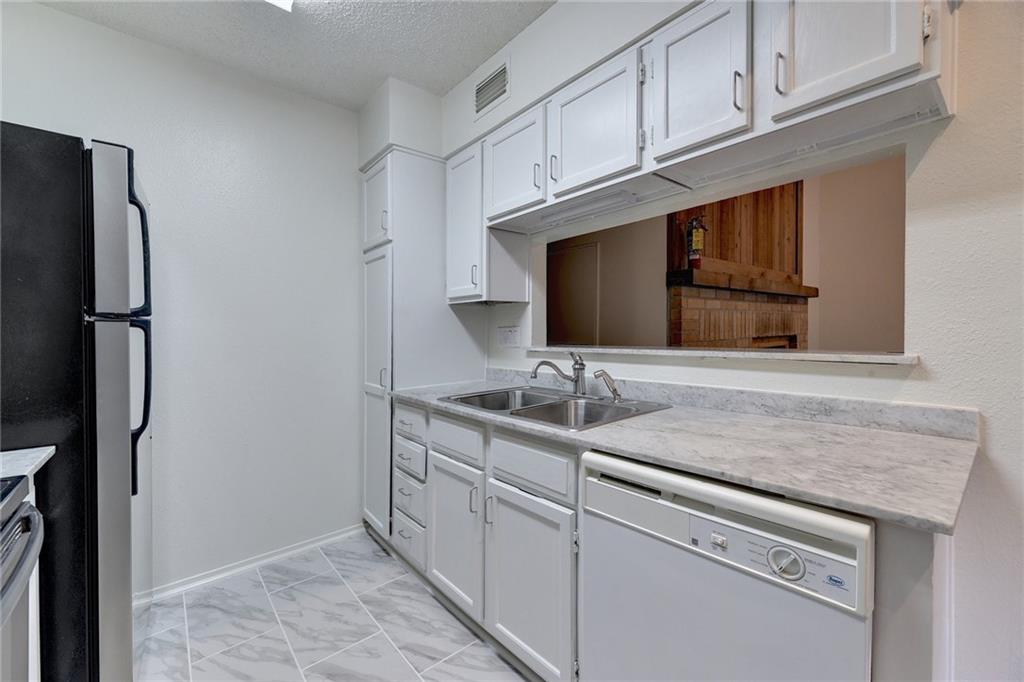908 Poplar Street, Unit 204 Austin, TX 78705 - Photo 5 of 15 a kitchen with stainless steel appliances granite countertop a sink and a refrigerator
