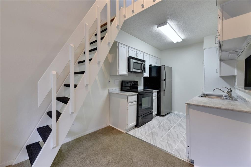 908 Poplar Street, Unit 204 Austin, TX 78705 - Photo 7 of 15 a kitchen with a refrigerator and a sink