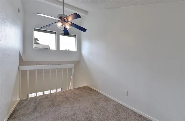 en empty room with windows and fan