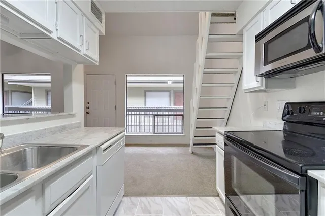 a kitchen with a sink and a stove top oven