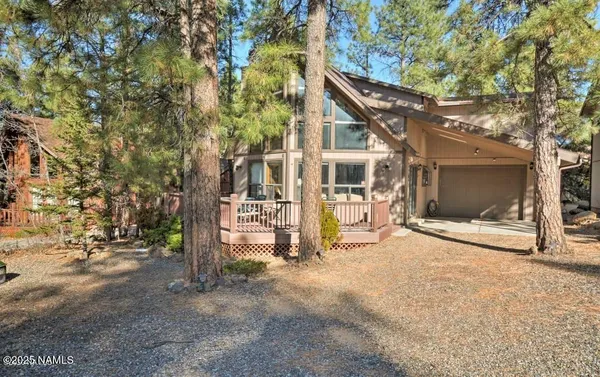a view of a house with backyard and trees