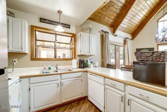 a kitchen with stainless steel appliances granite countertop a sink dishwasher a stove and a refrigerator with wooden floor