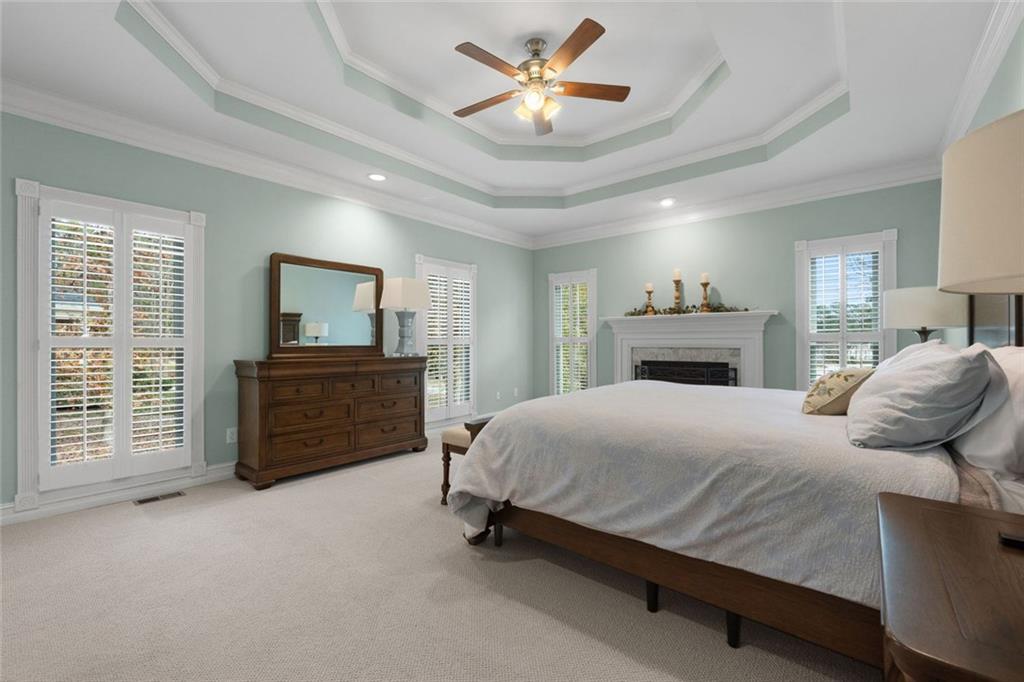 295 Springwater Chase Newnan, GA 30265 - Photo 25 of 68 a bedroom with a bed dresser and a fireplace