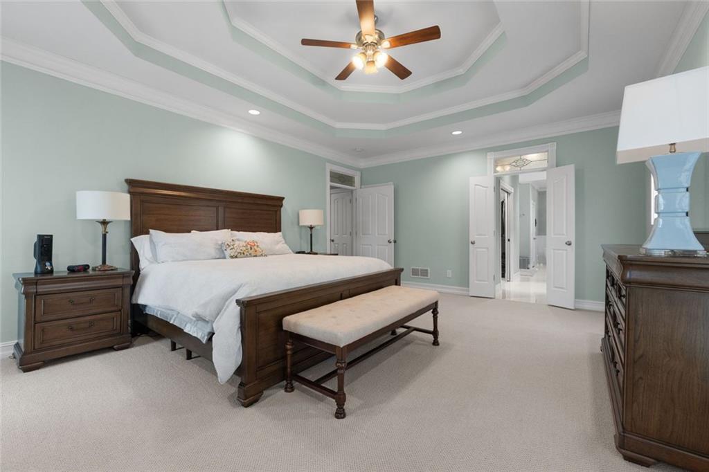 295 Springwater Chase Newnan, GA 30265 - Photo 28 of 68 a spacious bedroom with a bed and a chandelier