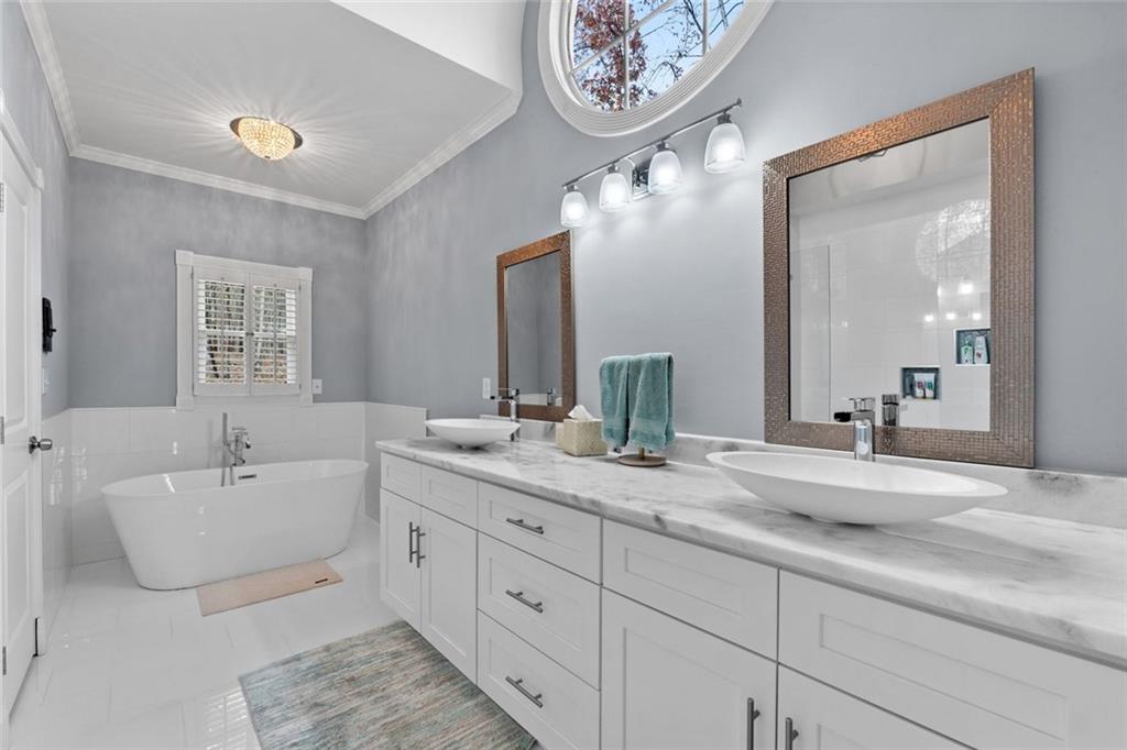 295 Springwater Chase Newnan, GA 30265 - Photo 31 of 68 a spacious en suite bathroom with a double vanity granite tub and a mirror