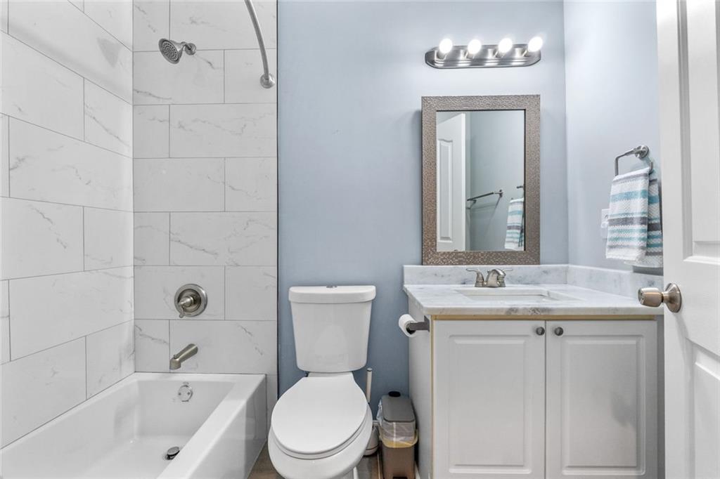 295 Springwater Chase Newnan, GA 30265 - Photo 42 of 68 a bathroom with a granite countertop toilet a sink and a mirror