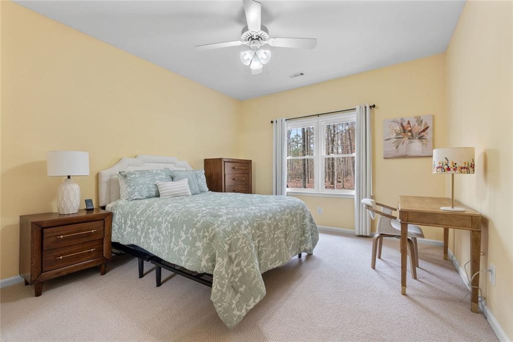 295 Springwater Chase Newnan, GA 30265 - Photo 46 of 68 a spacious bedroom with a bed and a table in it