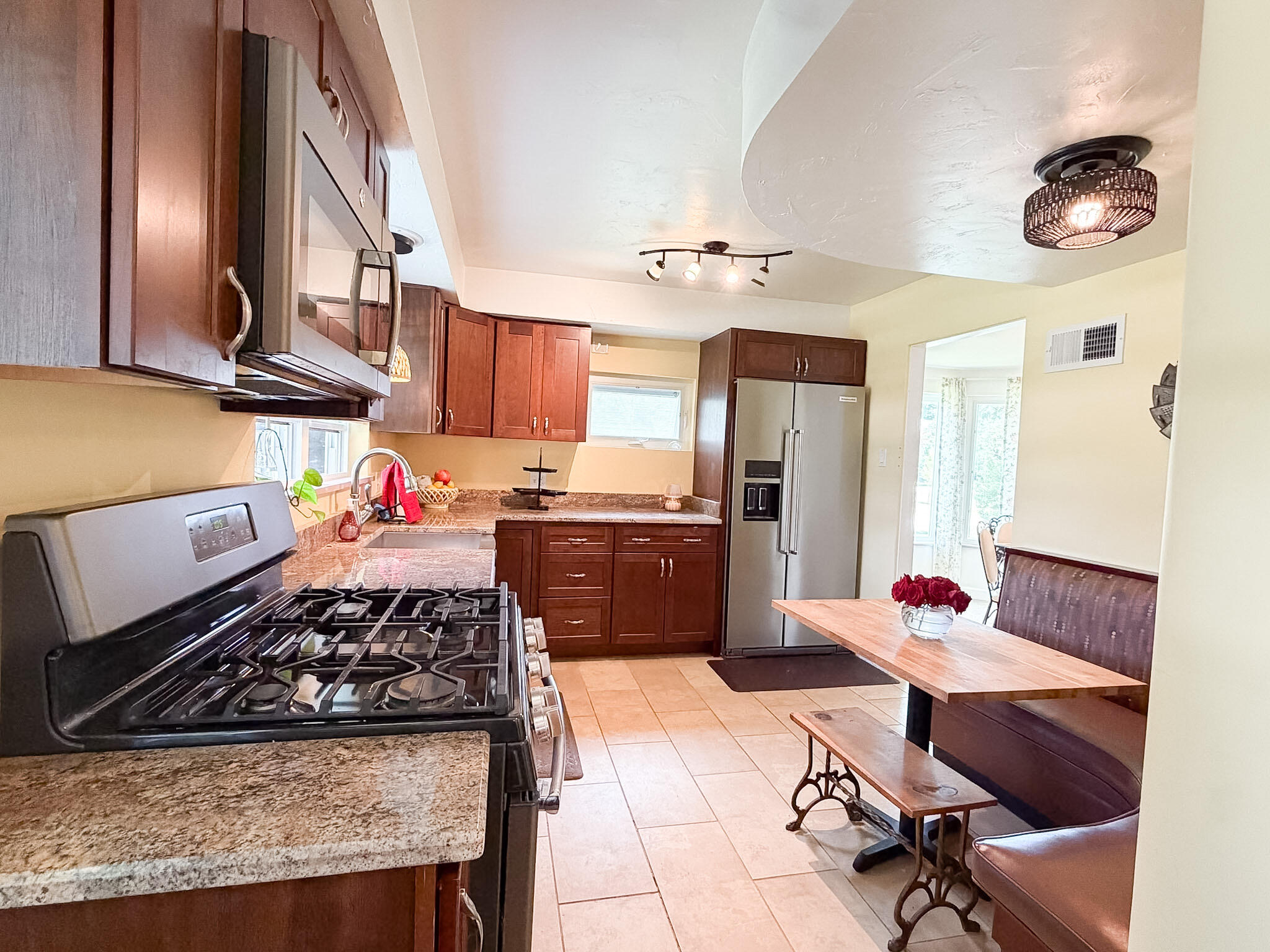 108 Beverly Place Munster, IN 46321 - Photo 15 of 47 a kitchen with stainless steel appliances granite countertop a stove a sink dishwasher a dining table and chairs with wooden floor