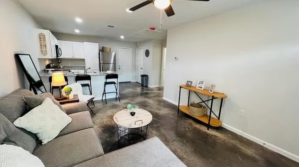 a living room with furniture and kitchen view