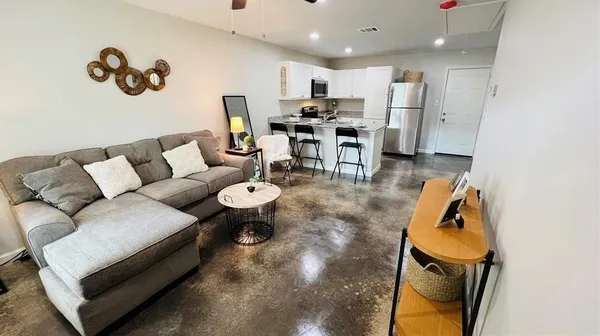 a living room with furniture and a kitchen view