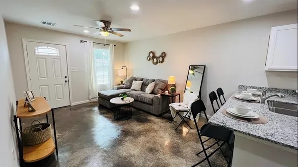 a living room with furniture and a chandelier