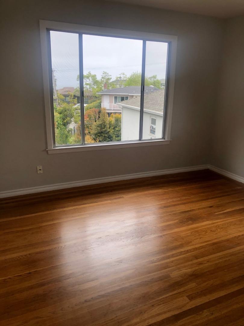 130 El Bonito Way Millbrae, CA 94030 - Photo 33 of 48 an empty room with wooden floor and windows