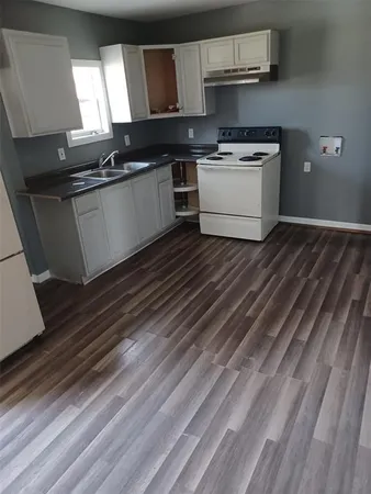 a kitchen with granite countertop a stove and cabinets