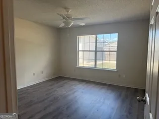 a view of an empty room with a window and wooden floor