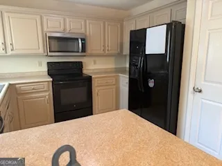a kitchen with a refrigerator stove and microwave