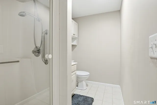 a bathroom with a toilet and a shower