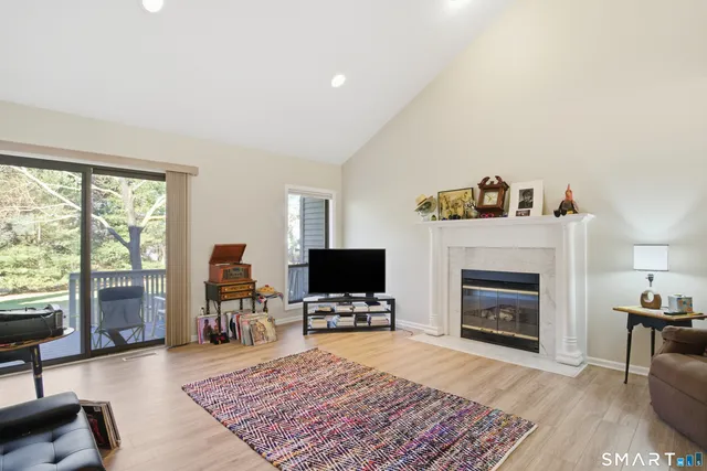 a living room with furniture a flat screen tv and a fireplace