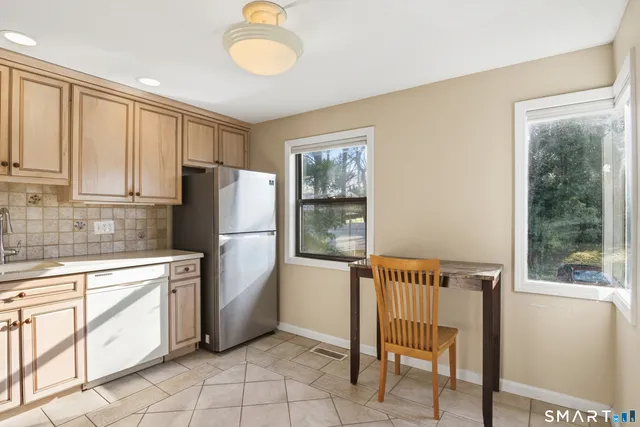 a kitchen with a refrigerator cabinets and wooden floor