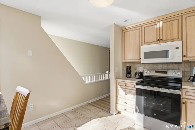 a kitchen with granite countertop a stove a sink and a microwave