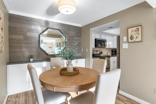 a dining room with wooden floor a glass table and chairs