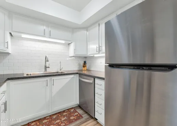 a kitchen with a sink a refrigerator and cabinets