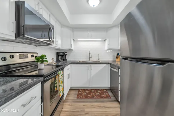a kitchen with stainless steel appliances granite countertop a sink stove and refrigerator