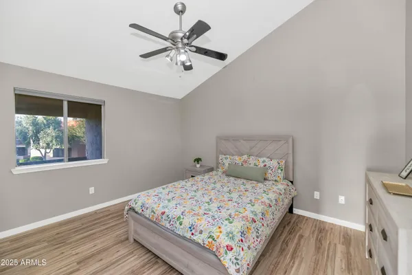 a bedroom with a large bed and a chandelier