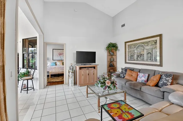 a living room with furniture a flat screen tv and a potted plant