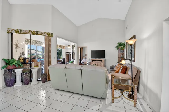 a kitchen with stainless steel appliances kitchen island granite countertop a stove a sink a refrigerator and a dining table with wooden floor