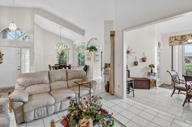 a kitchen with stainless steel appliances a refrigerator a stove a dining table and chairs with wooden floor