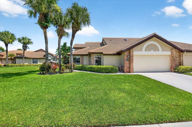 a front view of a house with a garden and yard