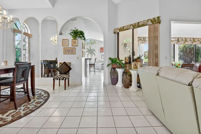 a view of a dining room with furniture a chandelier and a window