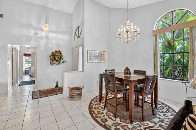 a dining room with furniture potted plants and wooden floor