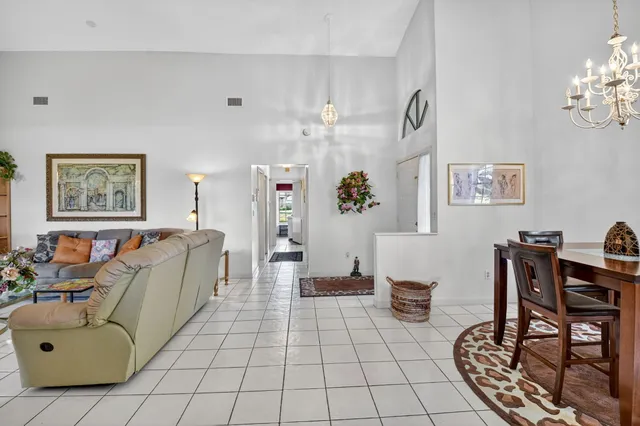 a dining room with furniture a potted plant and a chandelier