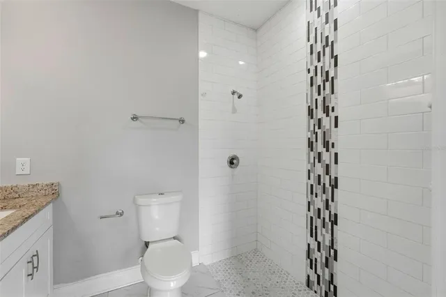 a bathroom with a toilet and a shower